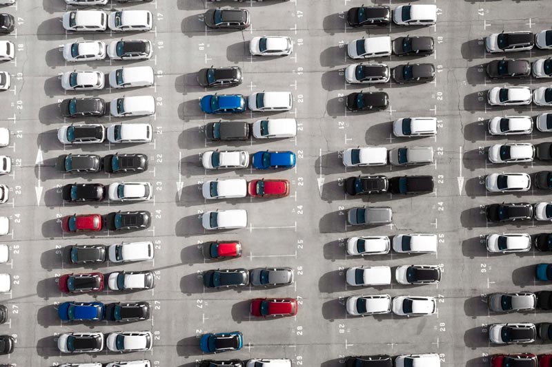 Vogelperspektive auf einen großen Parkplatz bei Gebrauchtwagen Ankauf Viersen, der mit Reihen weißer Autos gefüllt ist.